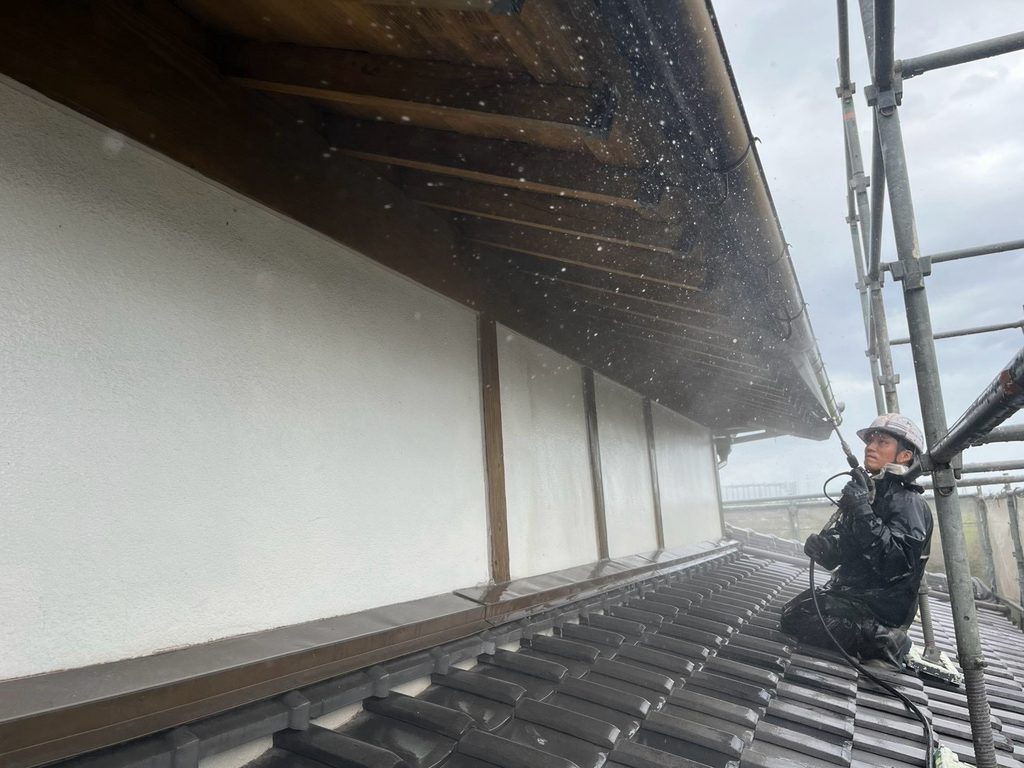 和風住宅の軒天と外壁を高圧洗浄する職人